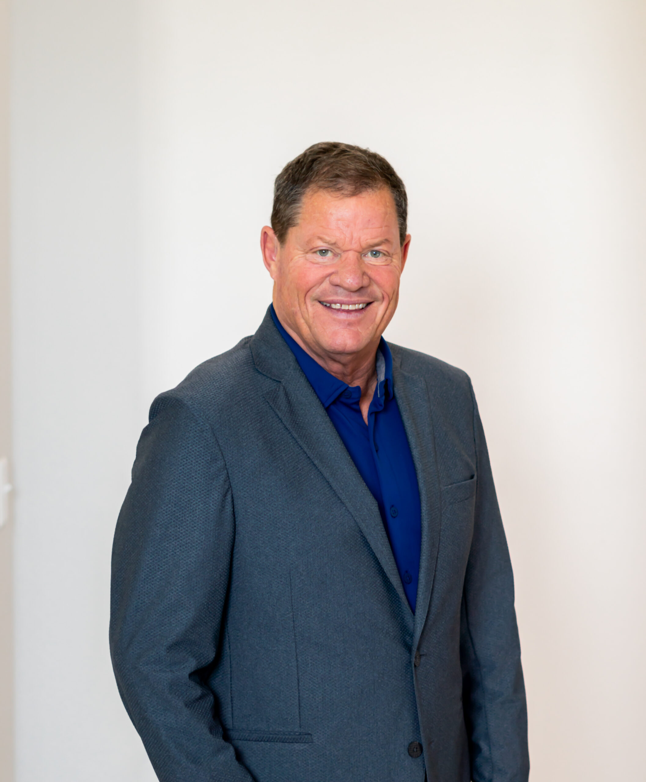 Bob David, real estate development partner, smiling in professional attire, showcasing expertise in real estate and property development.